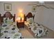 Well-lit bedroom featuring two beds with floral comforters and a shared nightstand at 913 Henley Cir, Davenport, FL 33896
