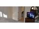Well-lit bedroom with a TV and dresser, featuring a closet and doorway to a well lit bathroom at 913 Henley Cir, Davenport, FL 33896