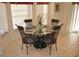 Cozy dining area featuring a round glass table and seating for four, illuminated by natural light from the window at 913 Henley Cir, Davenport, FL 33896