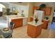 Bright kitchen featuring white appliances, a central island, and an open layout to the living area at 913 Henley Cir, Davenport, FL 33896