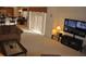 Open-concept living room with a large TV, comfortable sofa, and sliding glass doors, seamlessly connecting indoor and outdoor spaces at 913 Henley Cir, Davenport, FL 33896