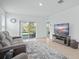 Bright living room with sliding glass doors to the patio and a gray sofa, perfect for relaxation at 993 King Parc Rd, Orange City, FL 32763