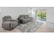 Inviting living room with a gray sofa, recliner, area rug, and access to the outdoor patio at 993 King Parc Rd, Orange City, FL 32763