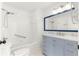 Updated bathroom with a blue vanity, white tiled walls, and a shower-tub combo at 11643 Sw 137Th Loop, Dunnellon, FL 34432