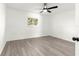 Bright bedroom with a ceiling fan, wood-look floors, and a large window at 11643 Sw 137Th Loop, Dunnellon, FL 34432