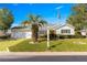 Charming single-story home with a well-manicured lawn, palm trees, and an American flag at 11643 Sw 137Th Loop, Dunnellon, FL 34432