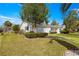 Well-manicured front lawn with a charming single-story home and mature trees at 11643 Sw 137Th Loop, Dunnellon, FL 34432