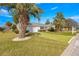 Well-manicured front lawn with mature palm trees and a charming single-story home at 11643 Sw 137Th Loop, Dunnellon, FL 34432