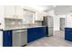 Modern kitchen featuring stainless steel appliances, granite countertops, and stylish blue and white cabinets at 11643 Sw 137Th Loop, Dunnellon, FL 34432