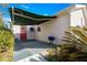 Back patio with a red entry door, a grill, and a partially extended retractable awning at 11643 Sw 137Th Loop, Dunnellon, FL 34432
