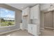 Charming kitchen featuring white cabinets, ample counter space, and a lovely view of the outside through the large window at 1251 Cresswind Blvd, Deland, FL 32724