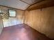 View of bedroom with paneled walls, window, and stained floor at 1348 Cr 605, Bushnell, FL 33513