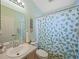 Bathroom featuring a sink with a large mirror, toilet, and a shower with patterned curtains at 136 Majestic Forest Run, Sanford, FL 32771