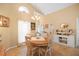 Comfortable dining room with a vaulted ceiling and arched window, next to a cabinet with shelf decor at 136 Majestic Forest Run, Sanford, FL 32771
