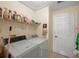 Well-equipped laundry room features a washer, dryer, shelving and tiled floors at 136 Majestic Forest Run, Sanford, FL 32771