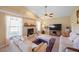Comfortable living room with a fireplace, tile floors, ceiling fan, and abundant natural light from the window at 136 Majestic Forest Run, Sanford, FL 32771