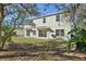 Backyard view of the home with a large grassy area and mature trees at 1368 Falconwood Ct, Apopka, FL 32712