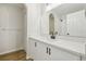 Modern bathroom with a large mirror, white cabinets, black fixtures, and wood-look floors at 1368 Falconwood Ct, Apopka, FL 32712