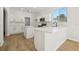 Bright kitchen features white cabinets, an island, stainless steel appliances, quartz counters, and wood-look flooring at 1368 Falconwood Ct, Apopka, FL 32712