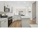 Open concept kitchen with stainless steel appliances, white cabinetry, island, and natural light at 1368 Falconwood Ct, Apopka, FL 32712