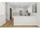 Modern white kitchen with stainless appliances, breakfast bar, and hardwood floors at 1368 Falconwood Ct, Apopka, FL 32712
