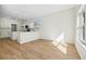 Open living room with white kitchen, bright window, and hardwood floors at 1368 Falconwood Ct, Apopka, FL 32712