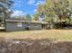 Expansive backyard featuring lush trees and mature landscaping, perfect for outdoor activities and relaxation at 1416 Braebury Dr, Leesburg, FL 34748