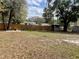 Fenced backyard featuring mature trees, storage shed, and wood pile at 1416 Braebury Dr, Leesburg, FL 34748