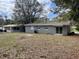 Spacious backyard showcasing a well-maintained lawn and mature trees, ideal for outdoor living at 1416 Braebury Dr, Leesburg, FL 34748