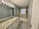 Clean bathroom featuring a granite vanity and tiled shower at 1416 Braebury Dr, Leesburg, FL 34748