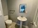 Well-lit half bath featuring a pedestal sink and toilet for convenience and functionality at 1416 Braebury Dr, Leesburg, FL 34748