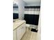 Well-lit bathroom with a white vanity and modern shower curtain at 1416 Braebury Dr, Leesburg, FL 34748