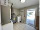 Bright laundry room with tile floors, washer, and water heater, provides convenience and functionality at 1416 Braebury Dr, Leesburg, FL 34748