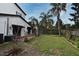 Backyard features a patio, lush lawn, mature palm trees, and a wood perimeter fence at 1611 Chestnut Ave, Winter Park, FL 32789