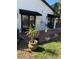 Brick patio features black awning-covered doors and tropical potted plants on a grassy lawn at 1611 Chestnut Ave, Winter Park, FL 32789
