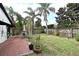 Spacious backyard features a brick patio with dining set, lush lawn, and perimeter wood fence at 1611 Chestnut Ave, Winter Park, FL 32789