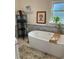 Bathroom featuring a modern soaking tub, tile accent wall, and black metal shelving at 1611 Chestnut Ave, Winter Park, FL 32789