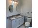 Bathroom featuring double sink vanity with gray countertop, modern fixtures and patterned tile accent wall at 1611 Chestnut Ave, Winter Park, FL 32789