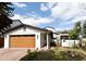 Charming single-Gathering home featuring a light-colored exterior, wood-look garage door, and well-manicured landscaping at 1611 Chestnut Ave, Winter Park, FL 32789