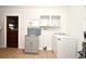 Functional laundry room featuring a utility sink, storage cabinets, and a modern washing machine at 1611 Chestnut Ave, Winter Park, FL 32789