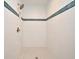 Modern walk-in shower with white tile and a decorative blue tile border at 1611 Chestnut Ave, Winter Park, FL 32789