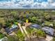An aerial view of a home nestled among lush trees, highlighted by its pristine pool and expansive driveway at 22 Sweetwater Creek Cir, Oviedo, FL 32765