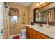 Bathroom with a wood vanity, framed mirror, shower with curtain, and a window with natural light at 22 Sweetwater Creek Cir, Oviedo, FL 32765
