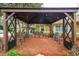 Outdoor seating area with elegant metal chairs inside a wooden pergola and lovely string lights at 22 Sweetwater Creek Cir, Oviedo, FL 32765