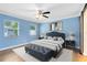 Light-filled bedroom with a large bed, bench, and windows at 2208 Page Ave, Orlando, FL 32806