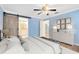 Light blue bedroom featuring rustic sliding barn door, white dresser, and decorative art at 2208 Page Ave, Orlando, FL 32806