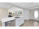 Modern kitchen with stainless steel appliances and white cabinets open to the living room at 2208 Page Ave, Orlando, FL 32806