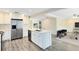 Bright, open kitchen features white cabinets, stainless steel appliances, and island with seating at 2208 Page Ave, Orlando, FL 32806