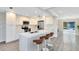 Modern eat-in kitchen featuring white cabinets, stainless appliances, and a large island with bar stool seating at 2208 Page Ave, Orlando, FL 32806