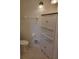 Cozy bathroom featuring tiled floors, corner cabinet storage, and standard toilet and towel rack at 2215 Hontoon Rd., Deland, FL 32720